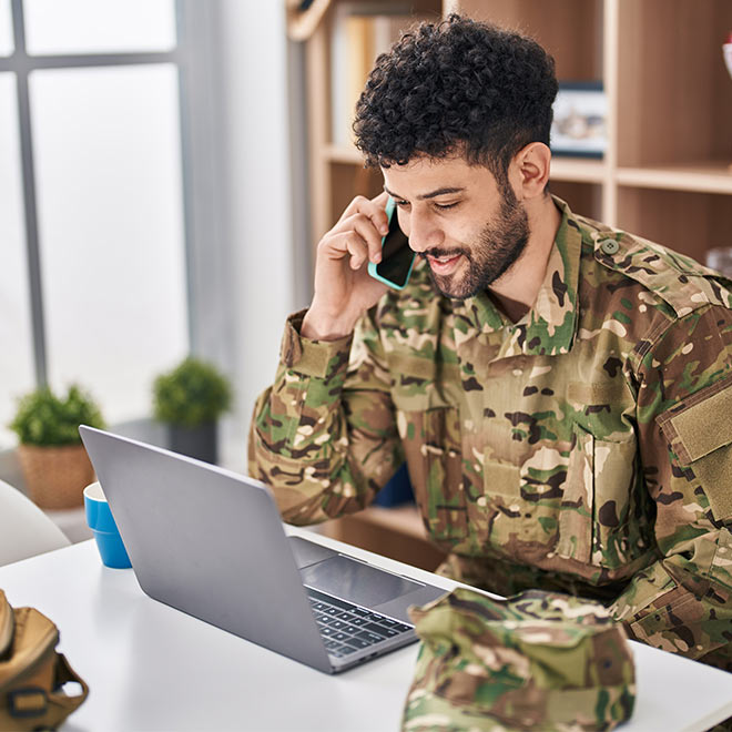 Man in a military uniform talking on a smartphone